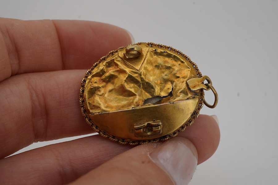 An ivory portrait miniature pendant, India, 19th century, depicting a woman in Mughal dress, in a gold mount with a rope twist chain border, to a pendant hoop, length 3.9cm, back damaged, later brooch fitting with pin de